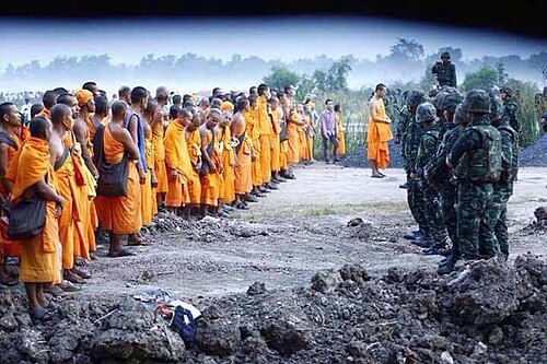 Monks stop the Thai military from searching the wat compound for Phra Dhammajayo