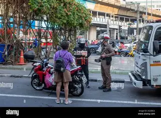 Royal Thai Police questioning a motor cyclist after an accident