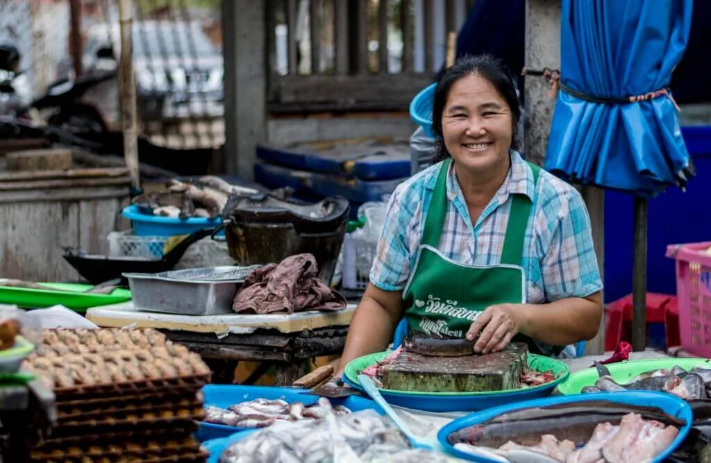A Thai food vendor smiling