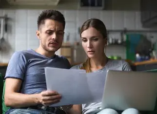 A couple examining a contract for house purchase very carefully
